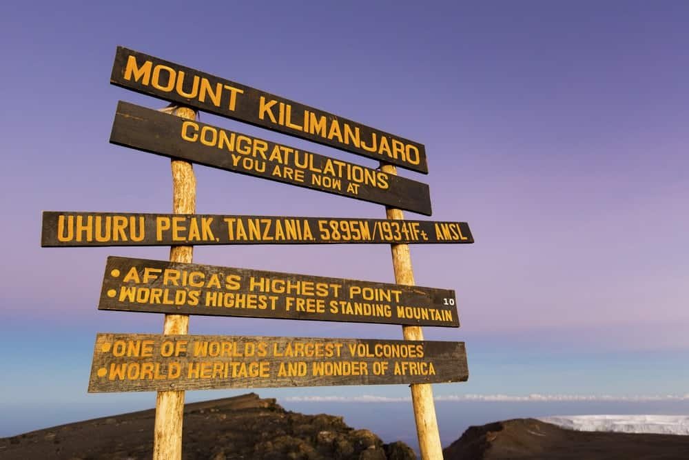 Snow-capped summit of Mount Kilimanjaro rising above the clouds at sunrise